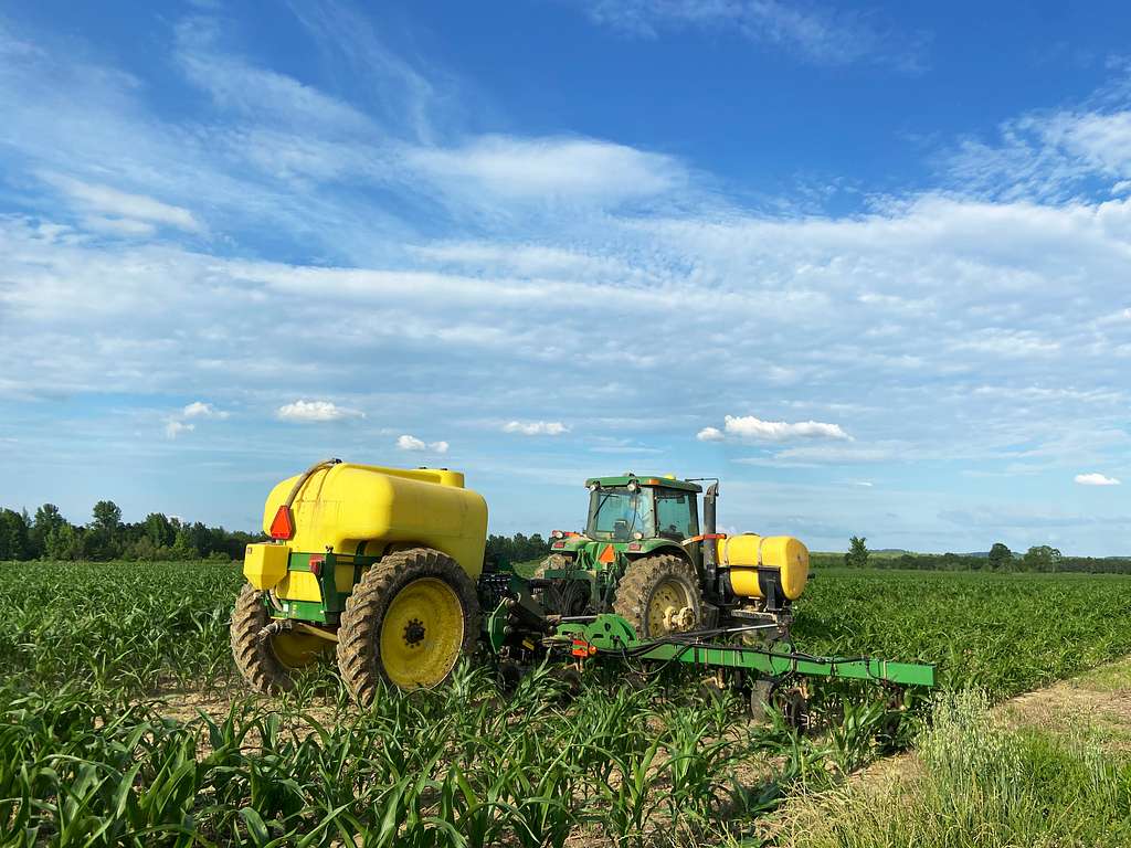 Fertilizer being spread by a tractor.